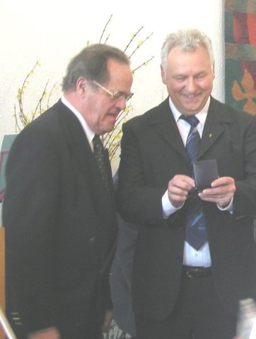 Jaskob Dinges �berreicht die Auszeichnung f�r Pfarrer Jakob Stehle